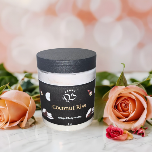 Jar of 'Coconut Kiss' whipped body frosting with roses on a marble surface