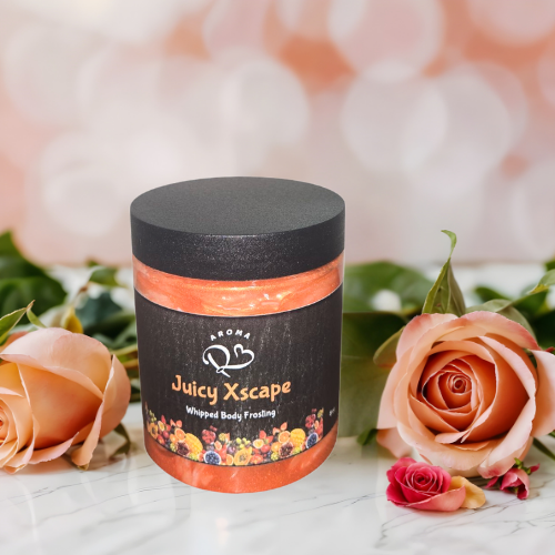 Jar of 'Juicy Xscape' whipped body frosting with roses on a marble surface